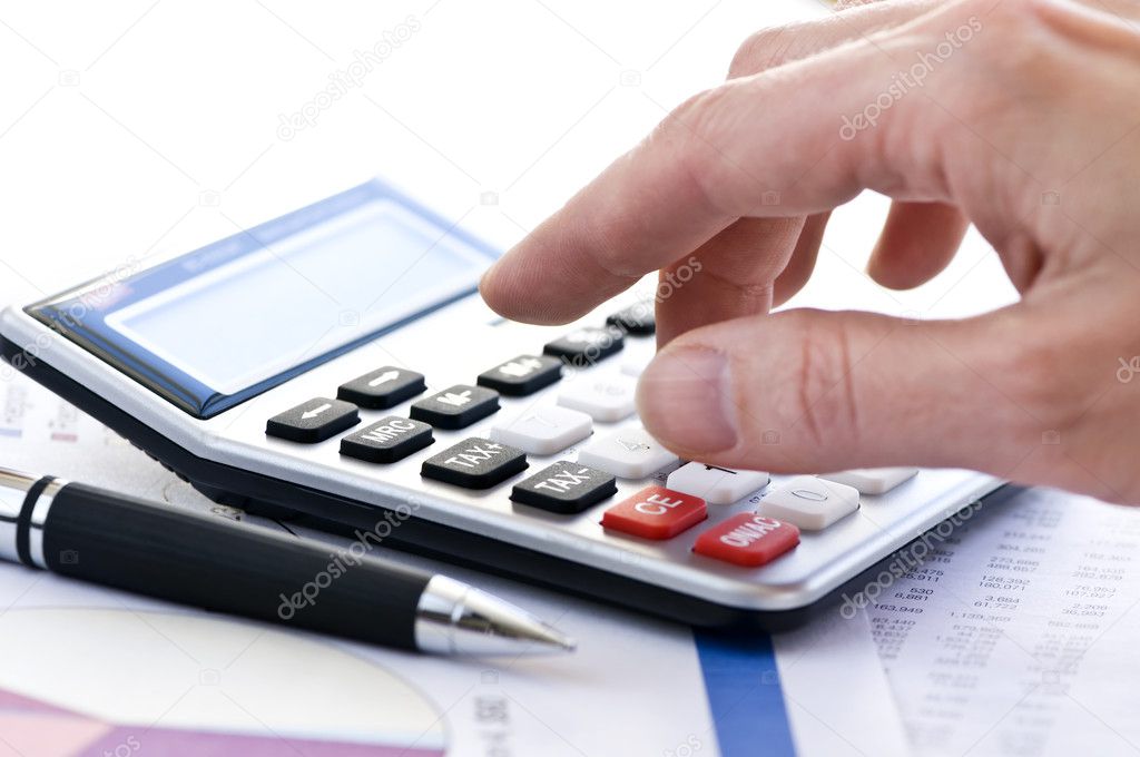 Typing numbers for income tax return with pen and calculator