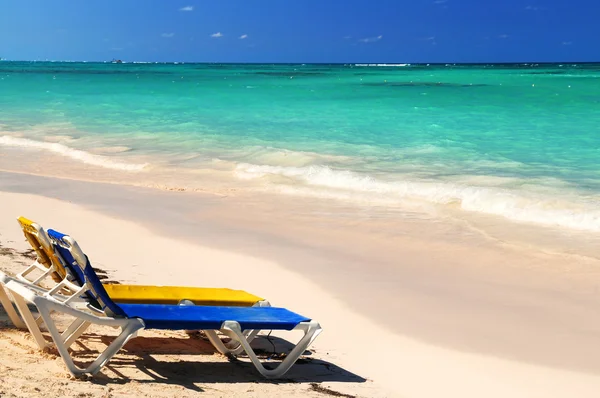 Liegestühle am tropischen Sandstrand — Stockfoto