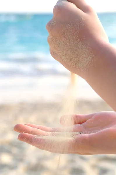 Handen gieten van zand op een strand — Stockfoto