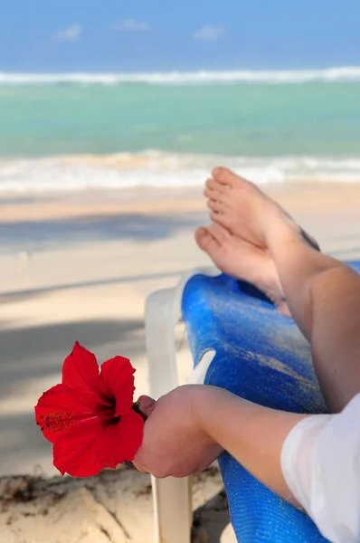 Genç Kadın Kırmızı Bir Çiçek Tutan Bir Tropik Sahilde Rahatlatıcı — Stok fotoğraf