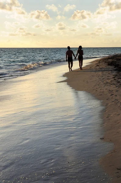 在热带度假区的沙滩上散步的情侣 — 图库照片