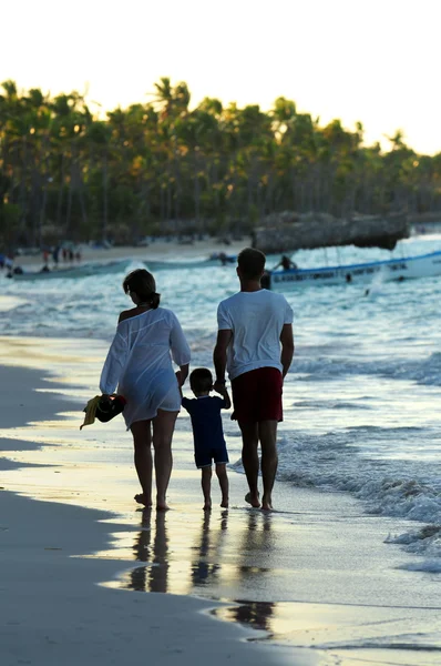 Familia caminando en una playa — Foto de Stock