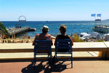 Couple relaxing in chairs in Cannes clipart