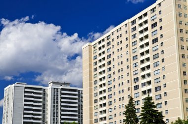 Tall residential apartment buildings with blue sky clipart