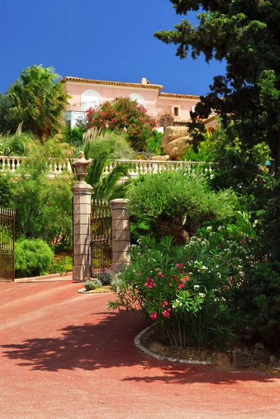 Giardino lussureggiante di fronte a una villa — Foto Stock