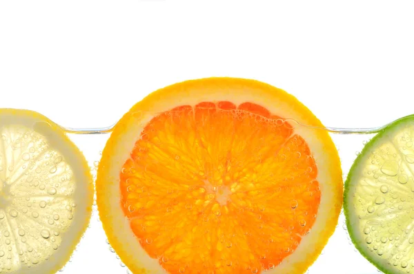 Φέτες Πορτοκαλιού Λεμονιών Και Ασβέστη Νερό Φυσαλίδες Αέρα Άσπρο Φόντο — Φωτογραφία Αρχείου