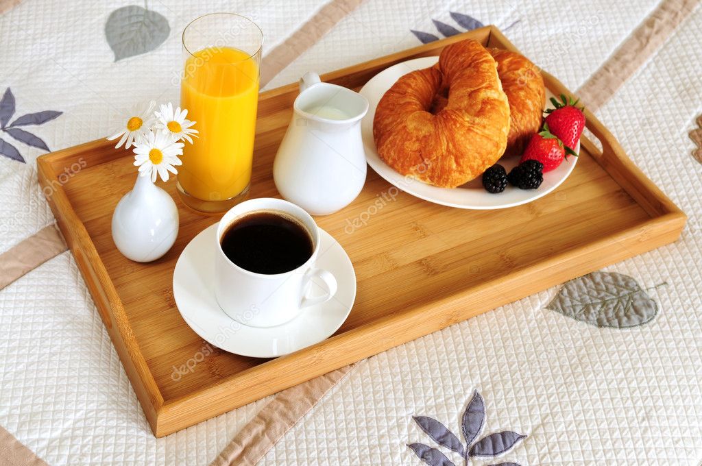 Breakfast on a bed in a hotel room - Stock Photo, Image. 