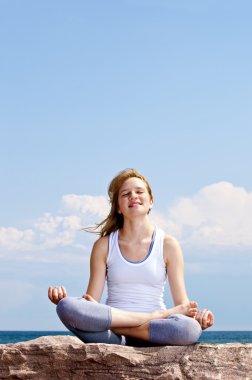 Genç kız dışarıda meditasyon yapıyor.