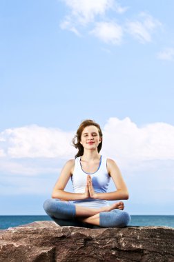 Genç kız dışarıda meditasyon yapıyor.