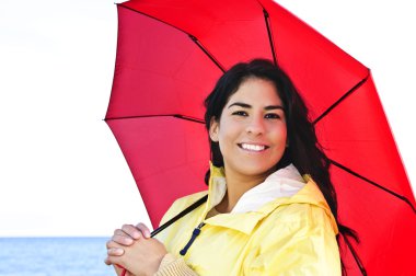 Beautiful young woman in raincoat with umbrella clipart