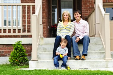 Young family sitting on front steps of house clipart