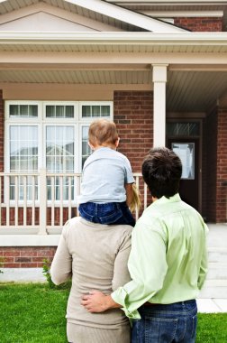 Happy family in front of home clipart