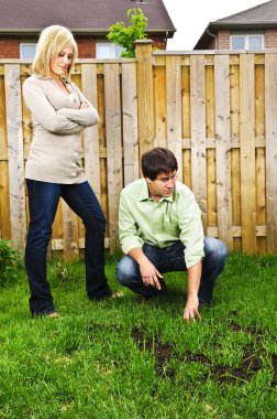 Young couple worried about growing lawn in backyard of new home clipart