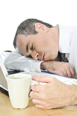 Tired businessman asleep at his desk isolated on white background clipart