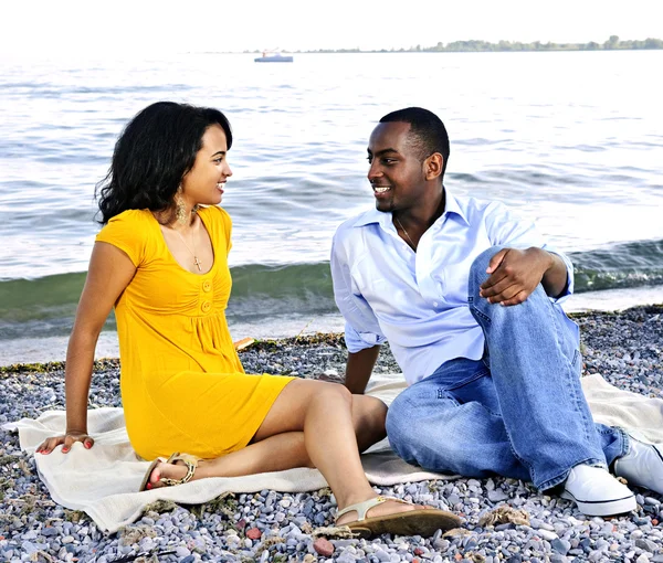 看着对方坐在海滩上的年轻浪漫情侣 — 图库照片