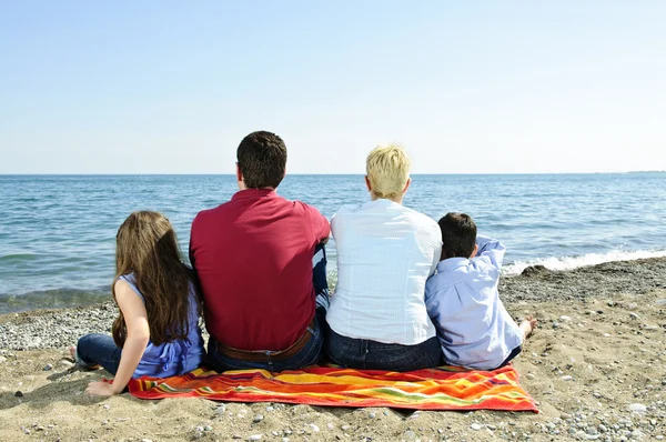 Famiglia seduta in spiaggia — Foto Stock