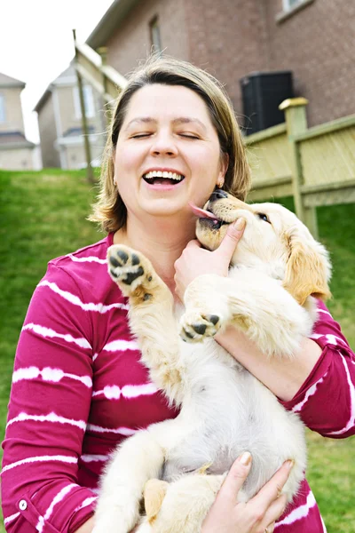 女性の持ち株のゴールデン リトリーバーの子犬を笑いの肖像画 — ストック写真