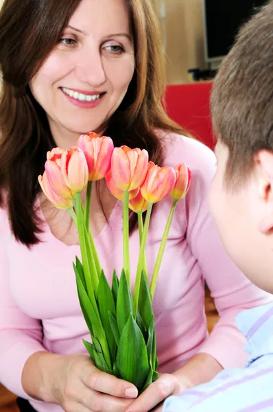 彼女の息子からの花の花束を受け取る母 — ストック写真