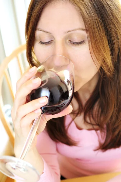 Mulher madura com um copo de vinho tinto — Fotografia de Stock
