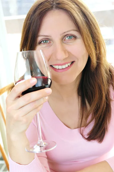 Bir Bardak Kırmızı Şarap Tutan Olgun Kadın Gülümsüyor — Stok fotoğraf
