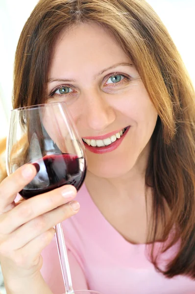 Mulher madura com um copo de vinho tinto — Fotografia de Stock
