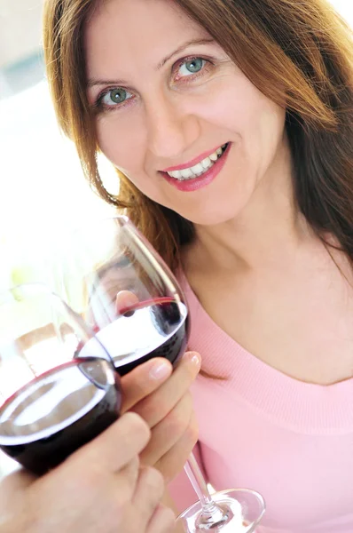 Reife Frau stößt mit Rotwein an — Stockfoto
