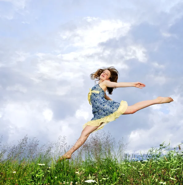 夏の草原の野生の花の中でジャンプ若い 代の少女 — ストック写真