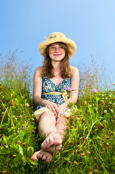 Young girl sitting in meadow — Stock Photo, Image