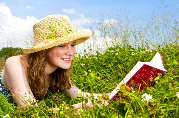 Jeune fille lecture livre dans prairie — Photo