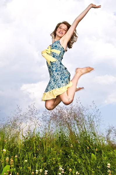 Jong meisje springen in de weide — Stockfoto