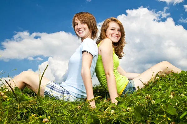Meninas jovens sentadas no prado — Fotografia de Stock