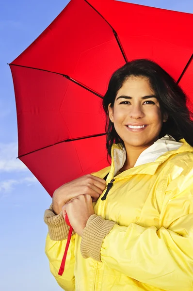 身穿黄色雨衣持红伞的美丽微笑着黑发女孩的肖像 — 图库照片