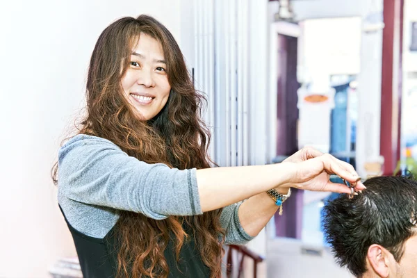幸せなヘアスタイリスト彼女のサロンで髪をカット — ストック写真