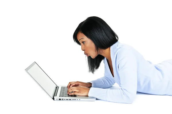 Verrast Zwarte Vrouw Leggen Met Computer Geïsoleerd Witte Achtergrond — Stockfoto