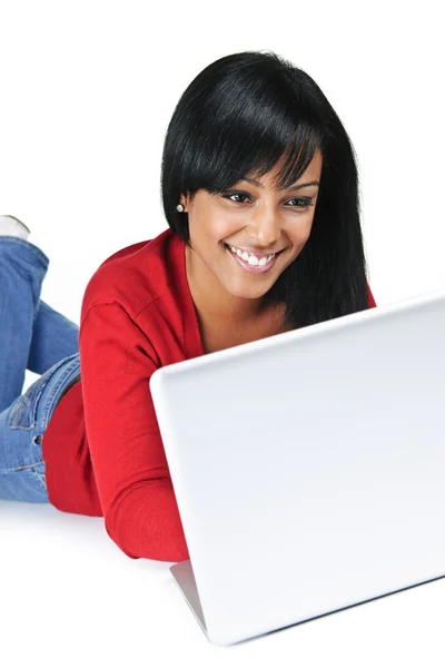 微笑躺地板上的电脑上打字的黑女人 — 图库照片