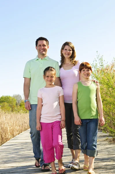 快乐的四人家庭走在木板上的肖像 — 图库照片