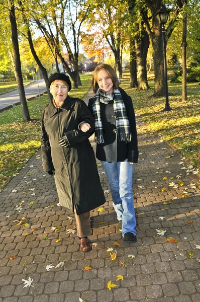 秋の公園で祖母と歩いて十代の孫娘 — ストック写真