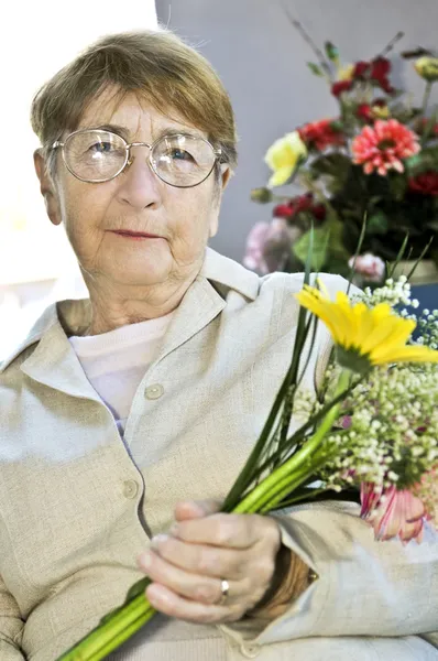 Ηλικιωμένη Γυναίκα Γυαλιά Κρατώντας Λουλούδια Και Χαμογελαστός — Φωτογραφία Αρχείου