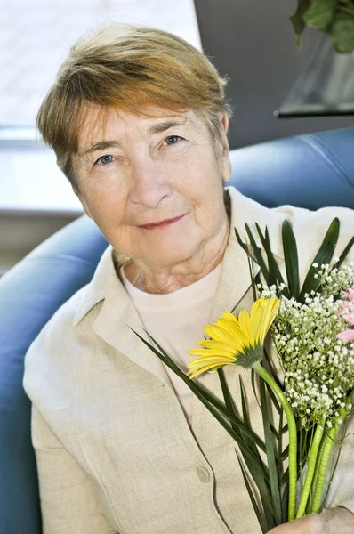 高齢者の女性の花の花束を保持していると笑みを浮かべて — ストック写真