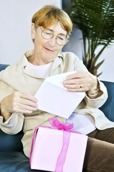 Пожилая Женщина Открывает Поздравительную Открытку Подарок — стоковое фото