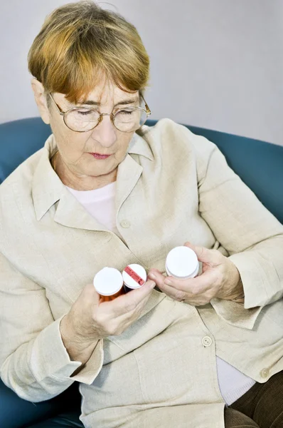 Äldre Kvinna Läser Varningsetiketter Piller Flaskor Med Medicinering — Stockfoto
