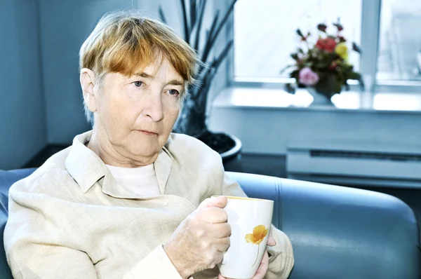 Çay Bardağı Ile Oturan Üzgün Yaşlı Kadın — Stok fotoğraf