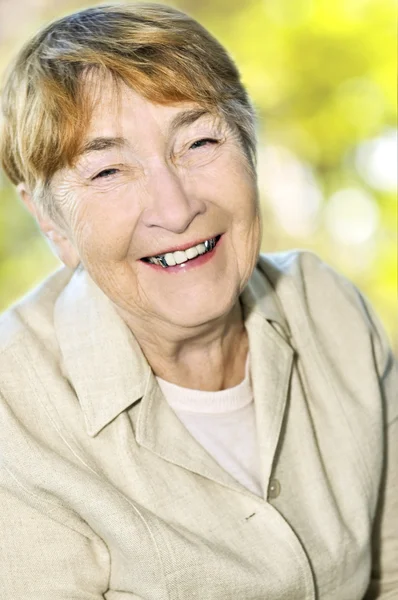 年配の女性は笑って 抽象的な背景に笑みを浮かべて — ストック写真