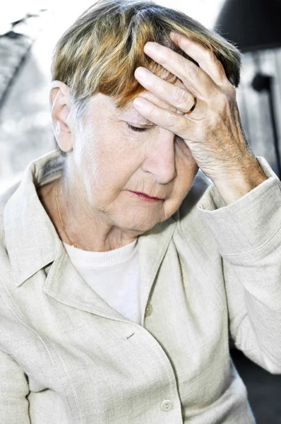 Elderly woman holding head — Stock Photo, Image