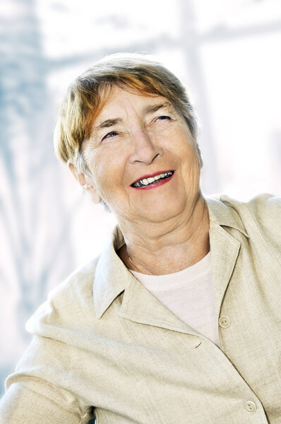 Senior woman laughing and smiling with abstract background