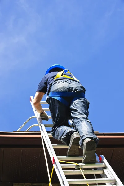 扩展的梯子爬到屋顶的建筑工人 — 图库照片