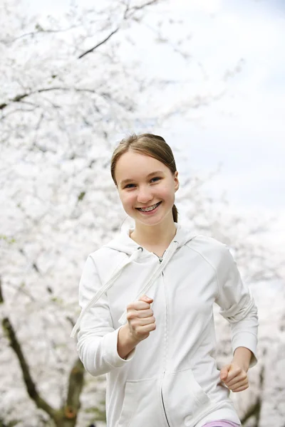 Mooie Tienermeisje Joggen Het Park Met Bloeiende Appelbomen — Stockfoto