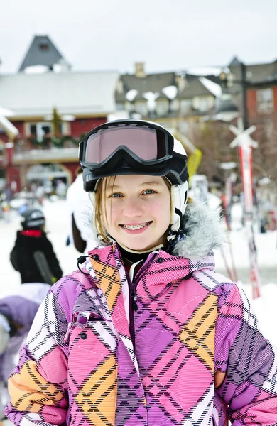 Счастливая девушка в лыжном шлеме на зимнем курорте — стоковое фото