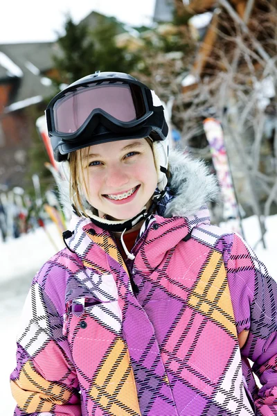 快乐少女在滑雪头盔和护目镜在冬天度假村的肖像 — 图库照片