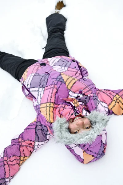 Flicka göra snöängel — Stockfoto